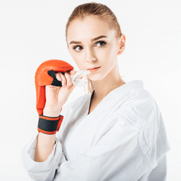 Girl practicing boxing and holding mouthguard