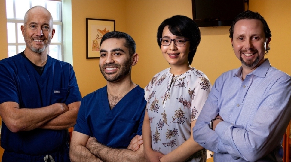 Four smiling orthodontists in Western Massachusetts standing with arms crossed