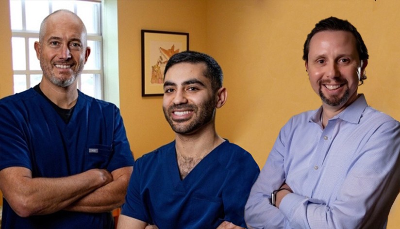 Four smiling orthodontists in Western Massachusetts standing with arms crossed