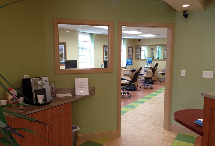 Light green waiting room peering into treatment room in Northampton orthodontic office