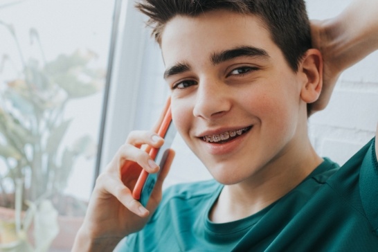 Young man with braces in Northampton talking on cell phone