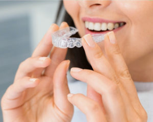 Close up of woman’s teeth wearing Invisalign