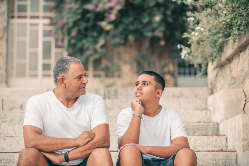 dad talking to son while on stairs