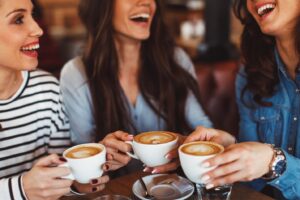three women drinking coffee together