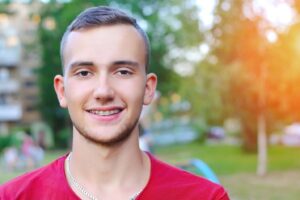 male teenager grinning with traditional braces