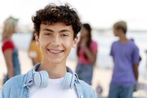 teenage boy wearing braces and hanging out with friends